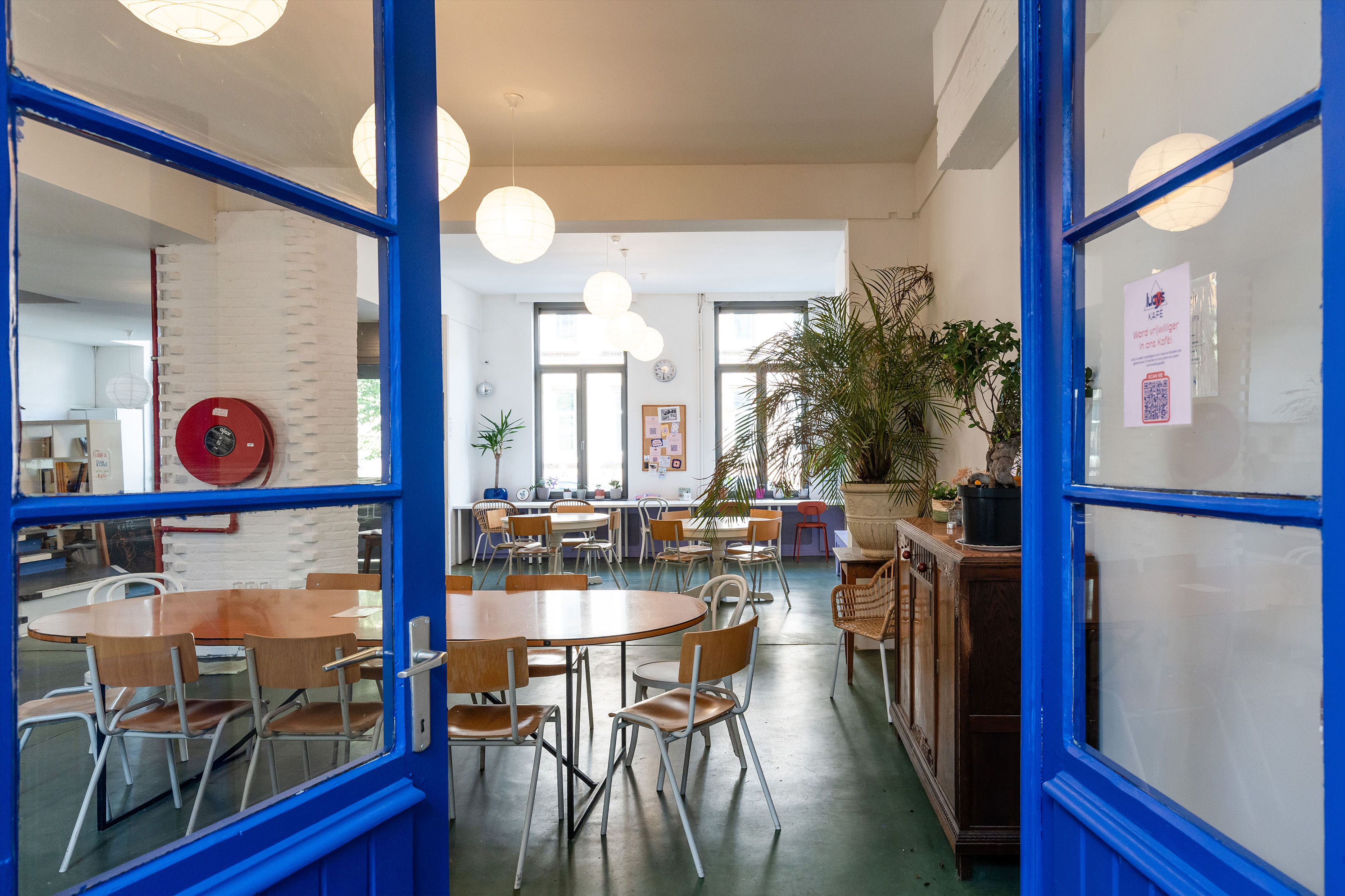 Zicht op een studeerruimte met ronde tafels bij Lucy's Antwerp