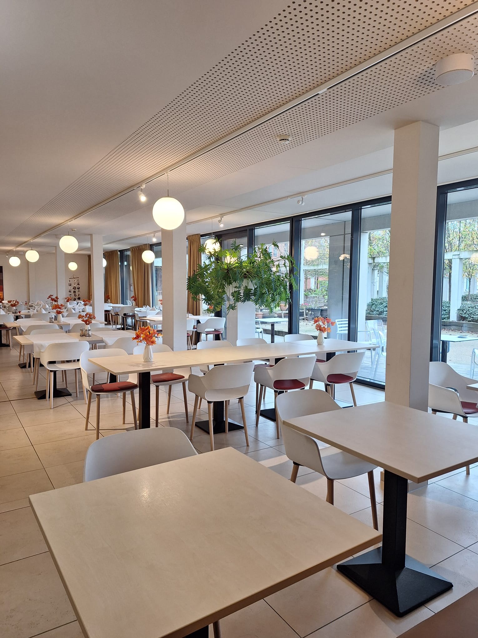 Zicht op de studeerruimte bij WZC Armonea Regatta. Er staan tafels en stoelen opgesteld in een ruimte met grote ramen.