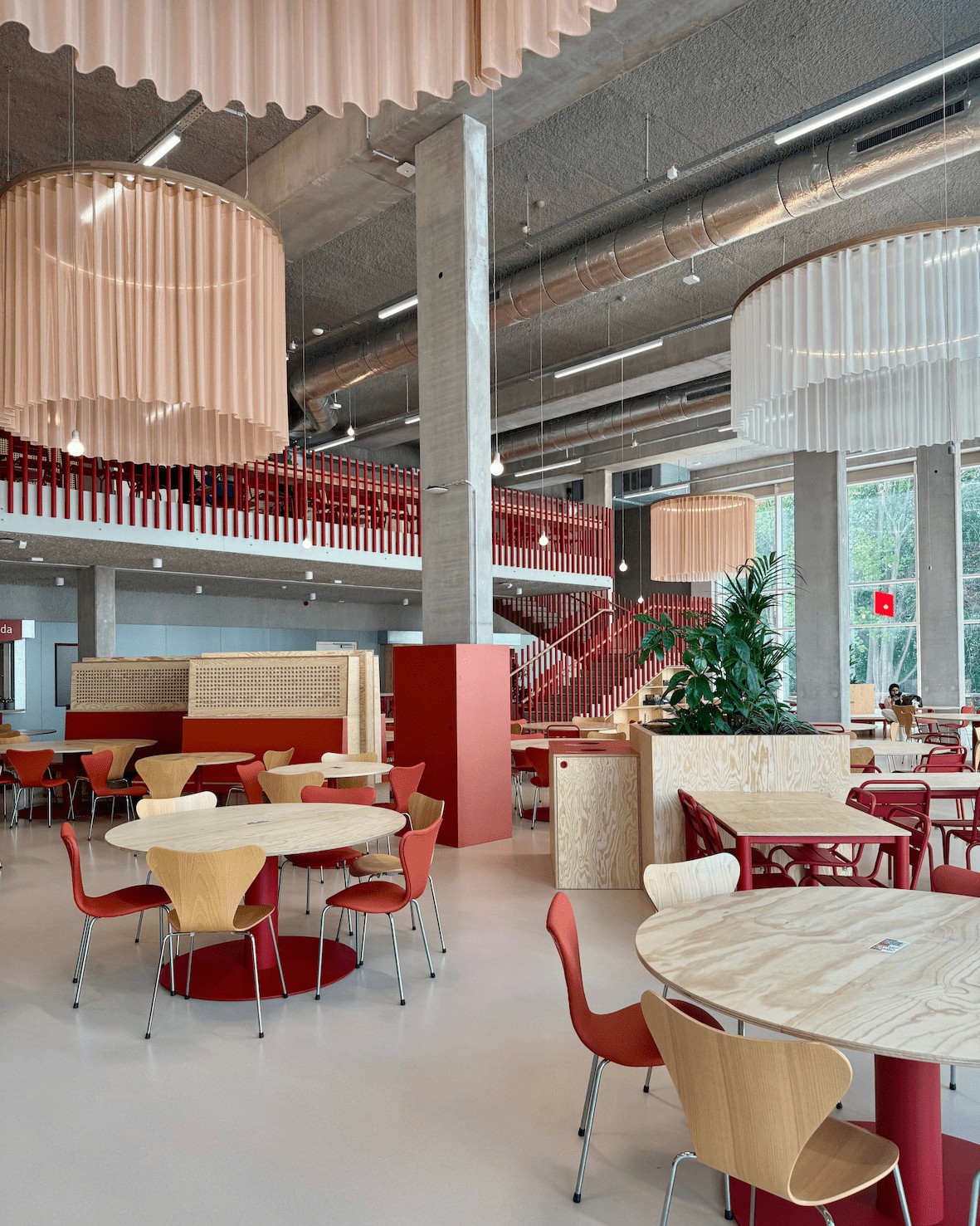 Zicht op het interieur van Bavet met ronde tafels, stoelen rondom, hoge plafonds en grote kroonluchters als eye catcher