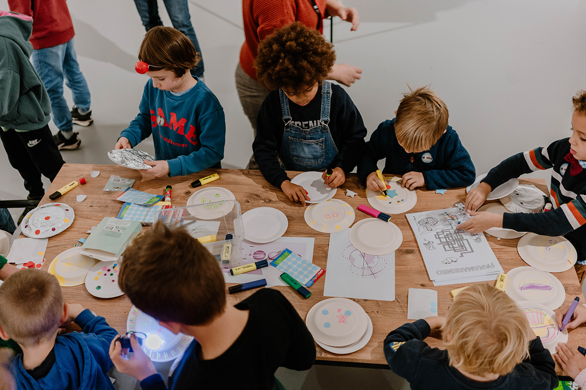 kinederen zitten samen rond een tafel te knutselen
