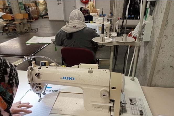 Een vrouw werkt aan een naaimachine