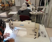 Een vrouw werkt aan een naaimachine