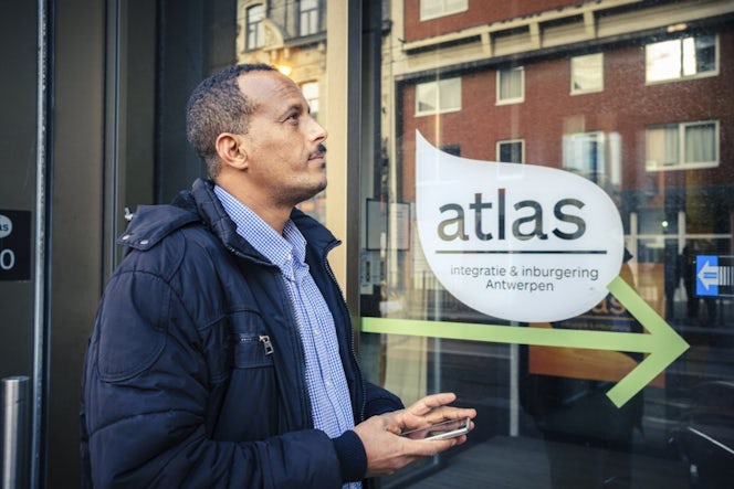 man staat bij gebouw van Atlas, integratie en inburgering