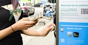 Vrouw betaalt aan parkeerautomaat