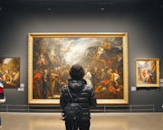 Vrouw voor groot schilderij in museum