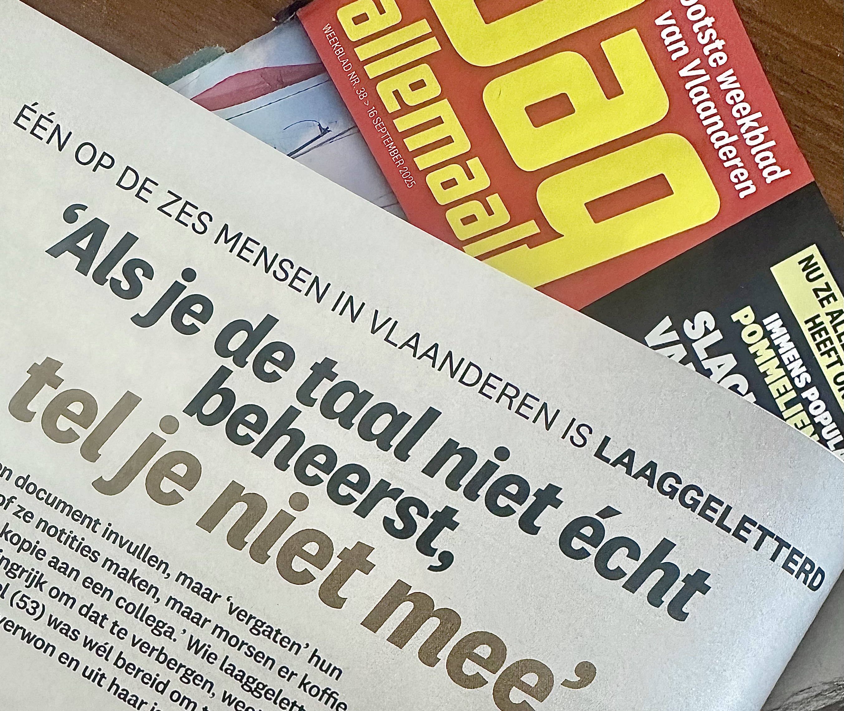 close-up van een artikel in Dag Allemaal met de kop 'Als je de taal niet écht beheerst, tel je niet mee' en een gele cover van het tijdschrift op de achtergrond