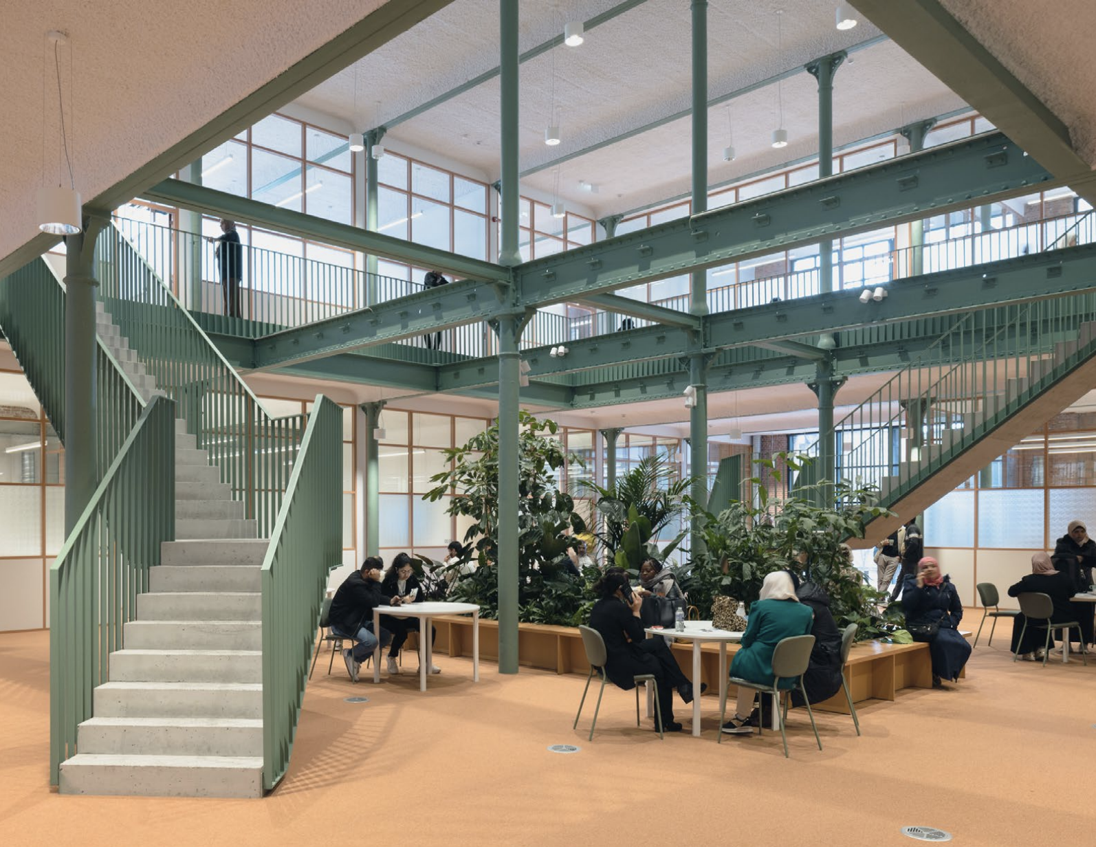 Lichtrijke ruimte met glazen dak, grote planten en open trap