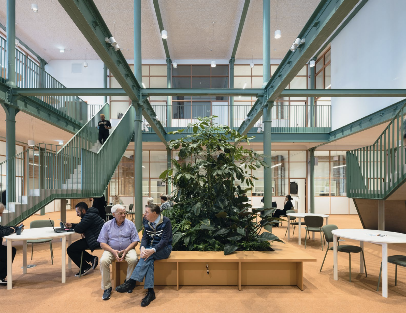 Glazen hal met planten, houten vloer en veel licht