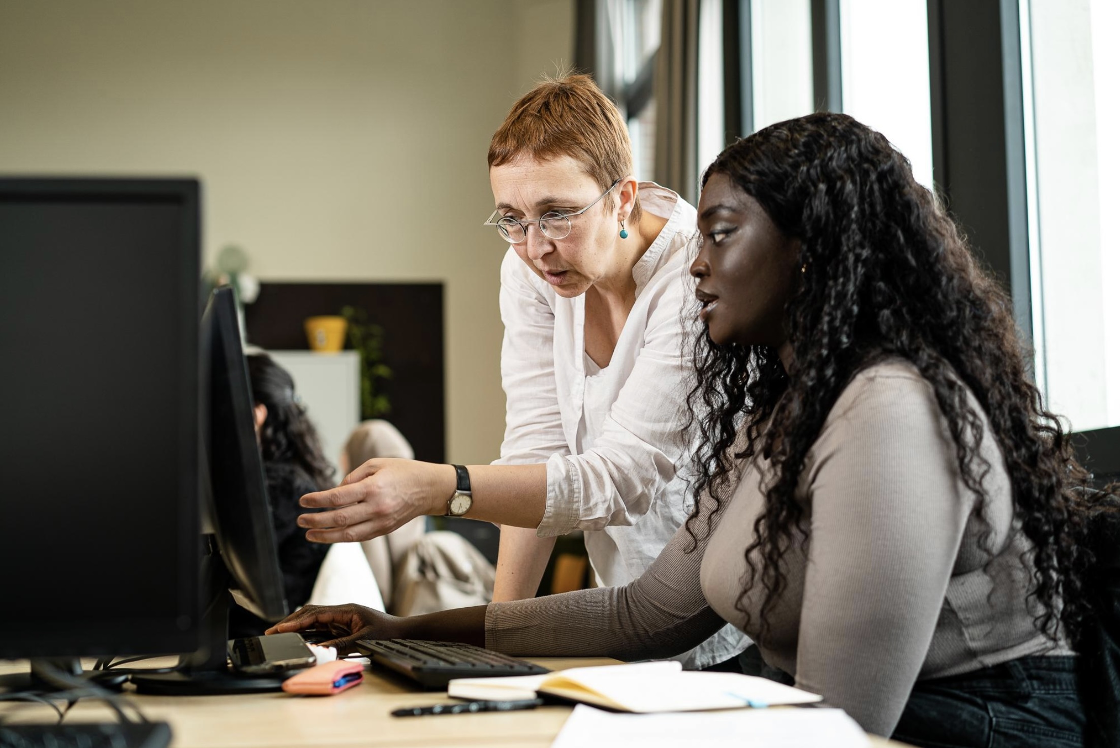 Vrouw krijgt les aan de computer