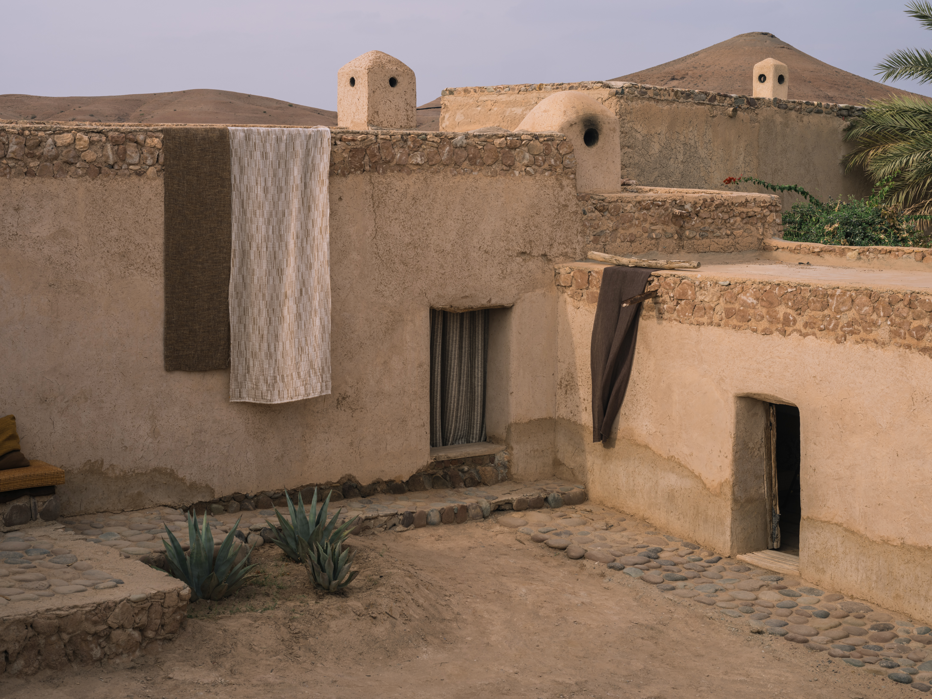 Drape BELAVALI YP26005, PONERE YP26004, Curtain TARANGA YP26001, Drape BHUMIRA YP26005 photographed in Studio KO's traditional Moroccan farm for the Azimuth 2026 fabric collection by Designs of the Time