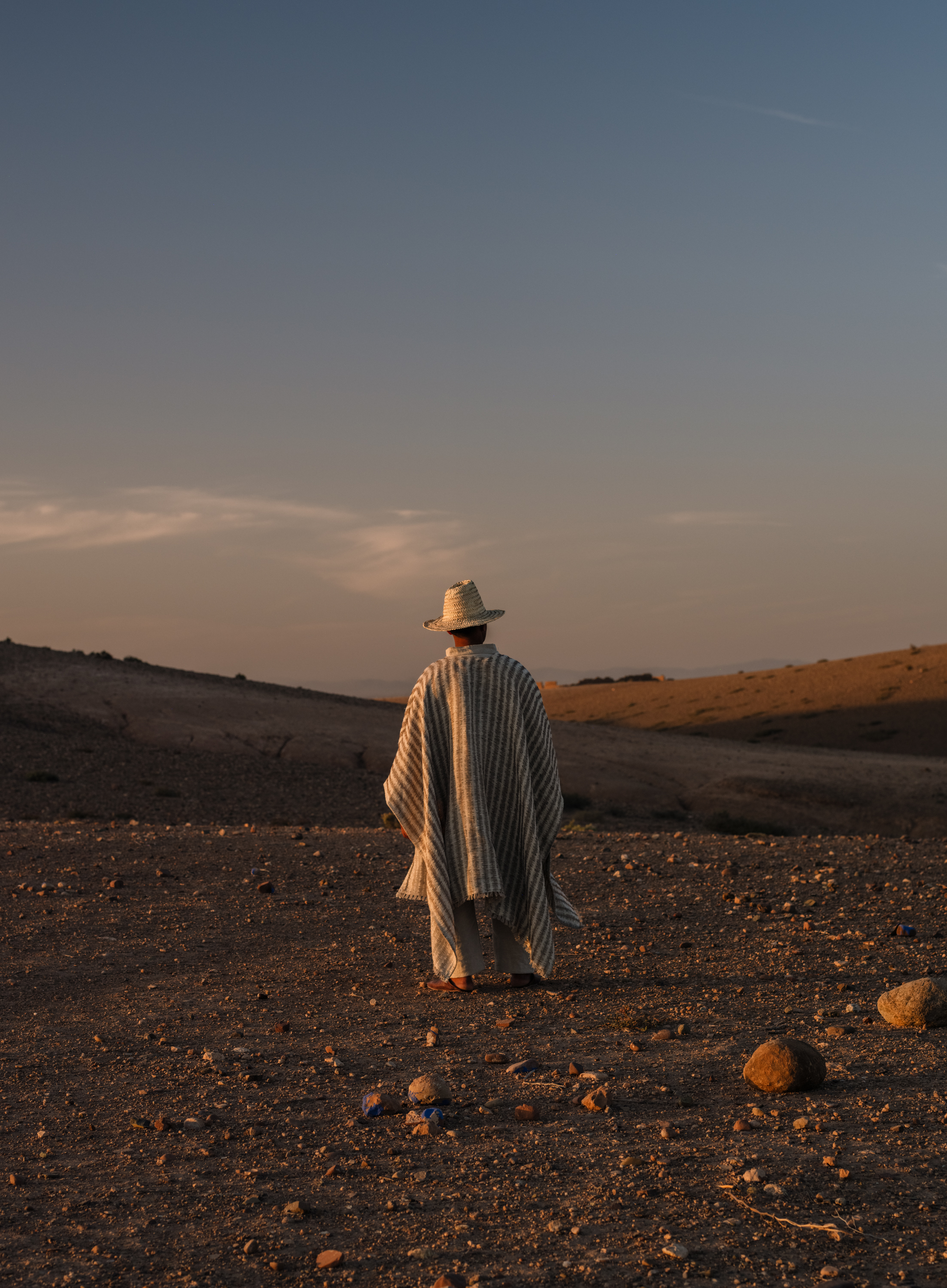 Man wearing a cape made of TARANGA YP26001 fabric photographed in the Moroccan desert for the Azimuth 2026 fabric collection by Designs of the Time