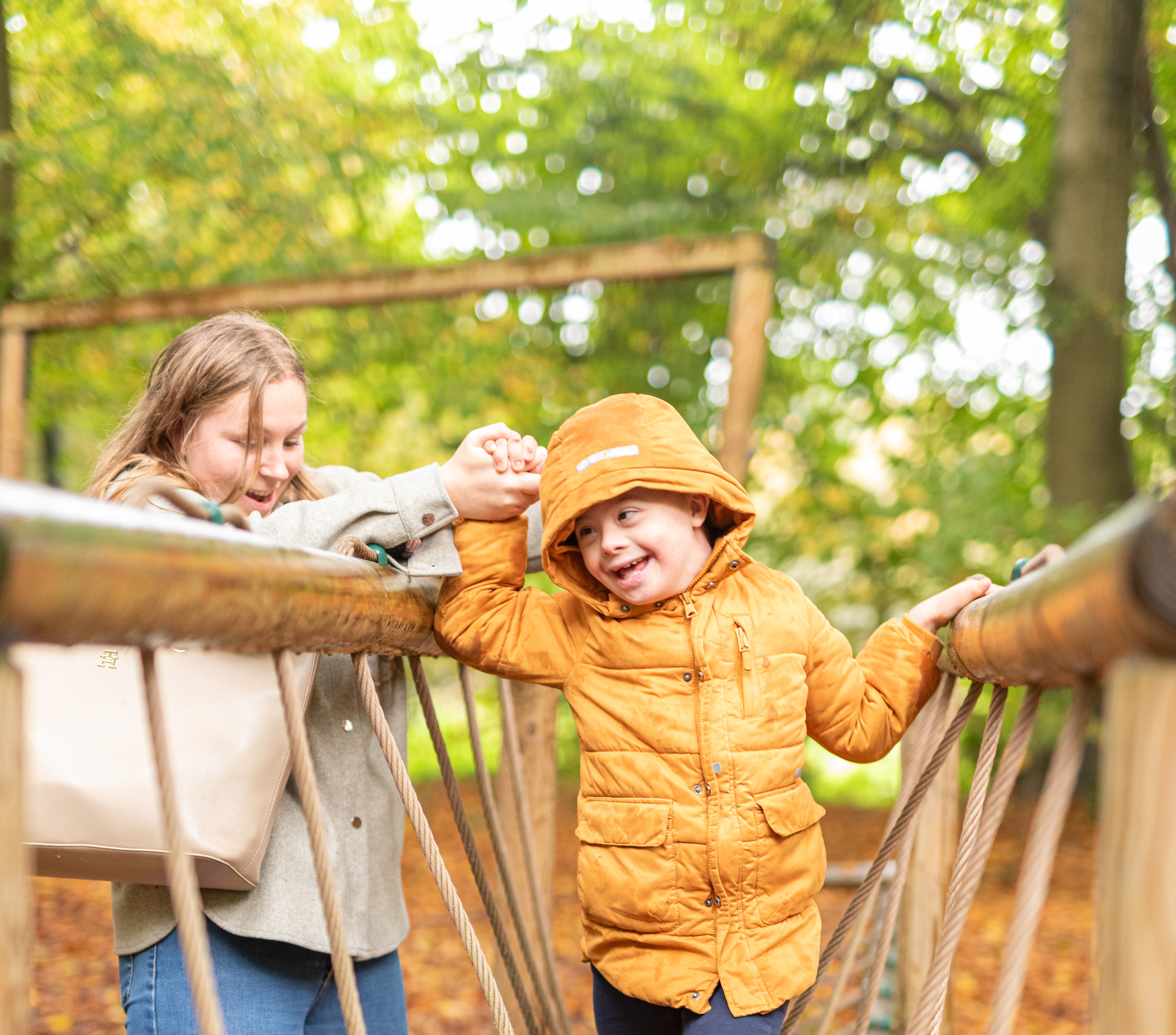 Jobstudent Laura begeleidt jongen in het speelbos tijdens een uitstap van KJW