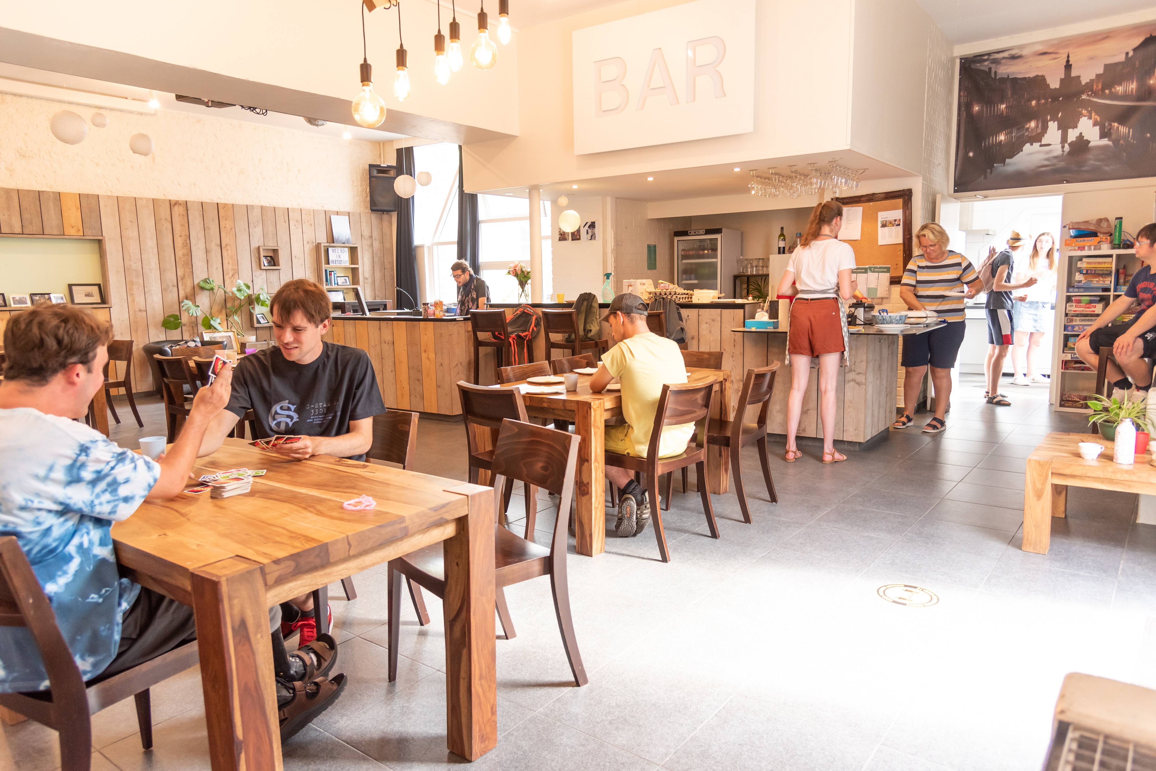 Een groep mensen zit in een bar en ontspant op verschillende manieren