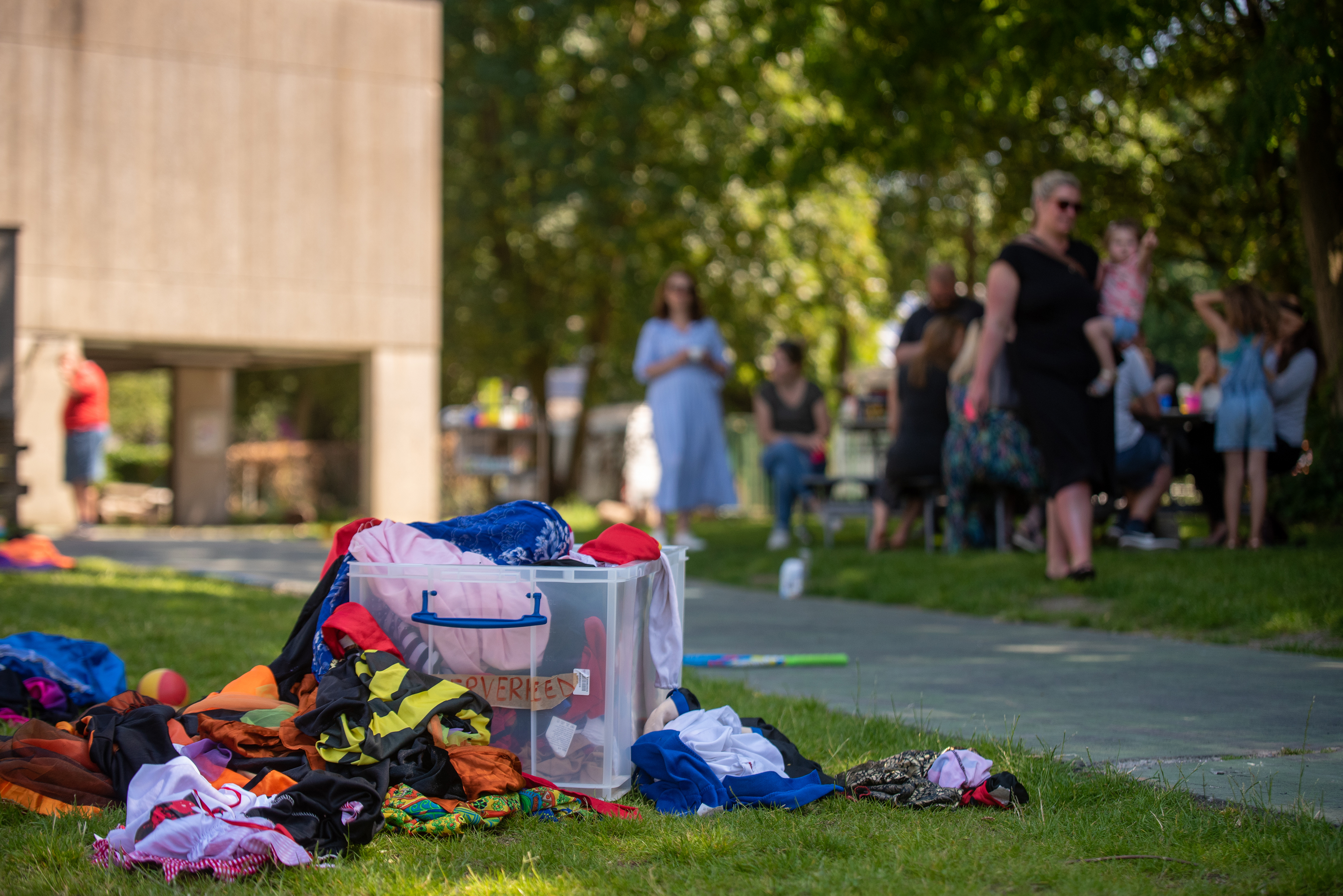 Speelkoffer in het gras waar mensen met kinderen samen zijn