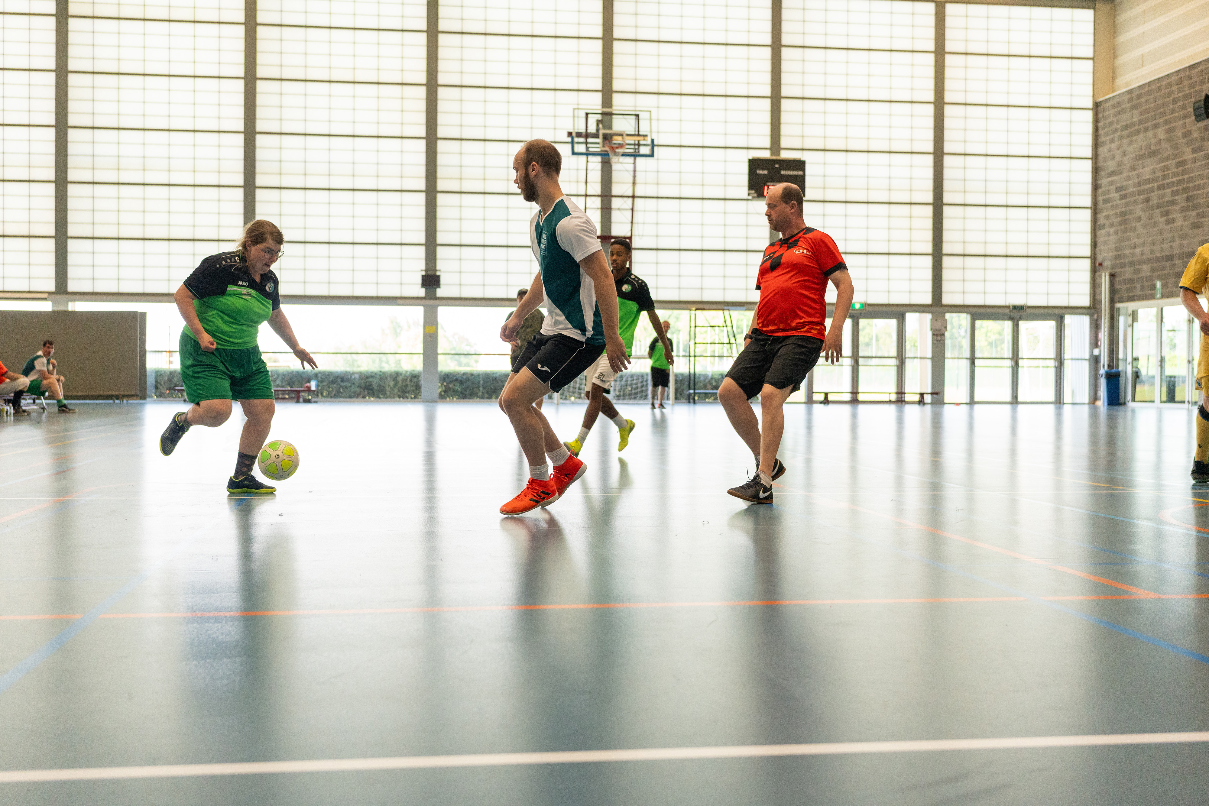 Een voetballende vrouw in actie tegen verdedigers