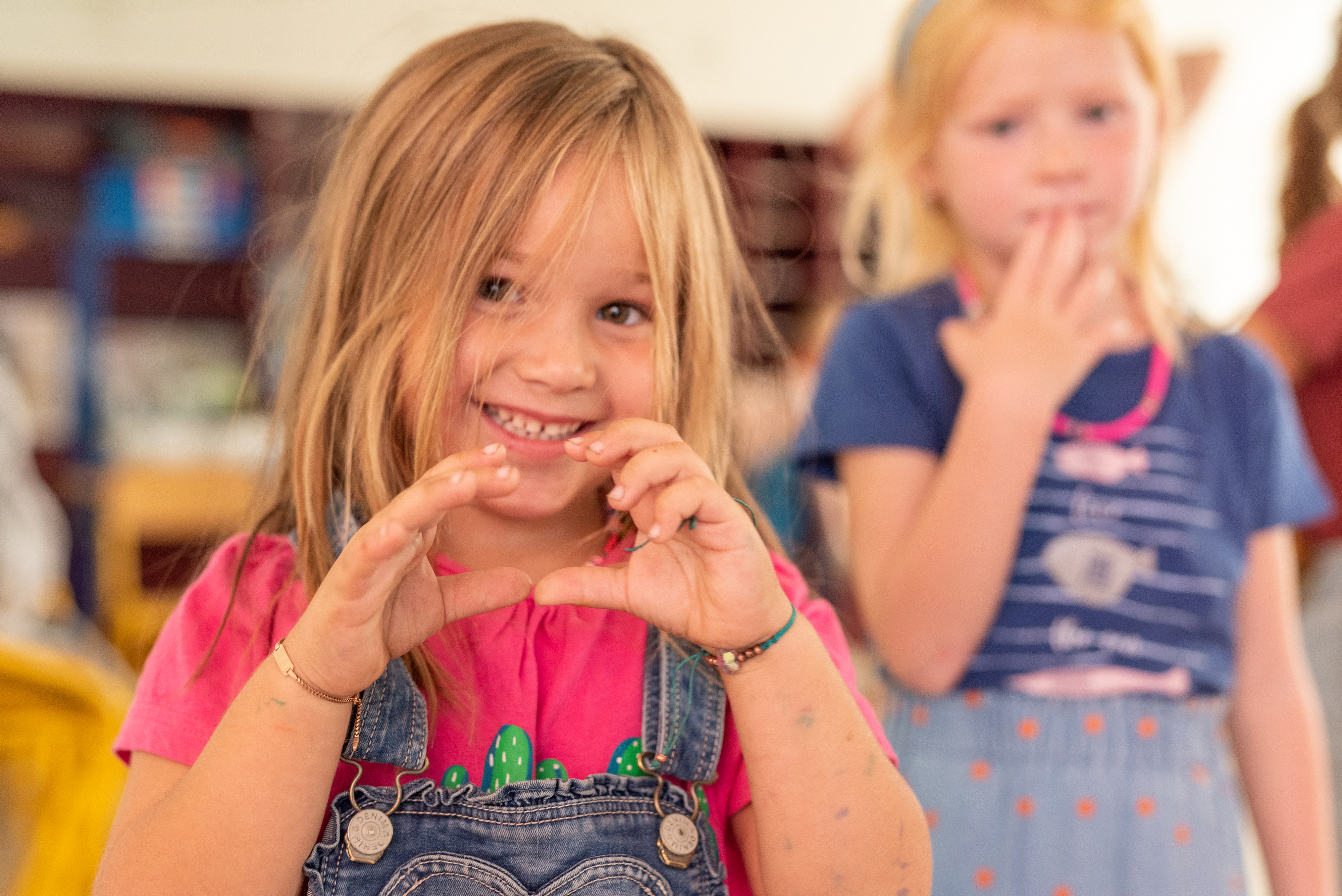 Vrolijk meisje maakt hartje met haar handen