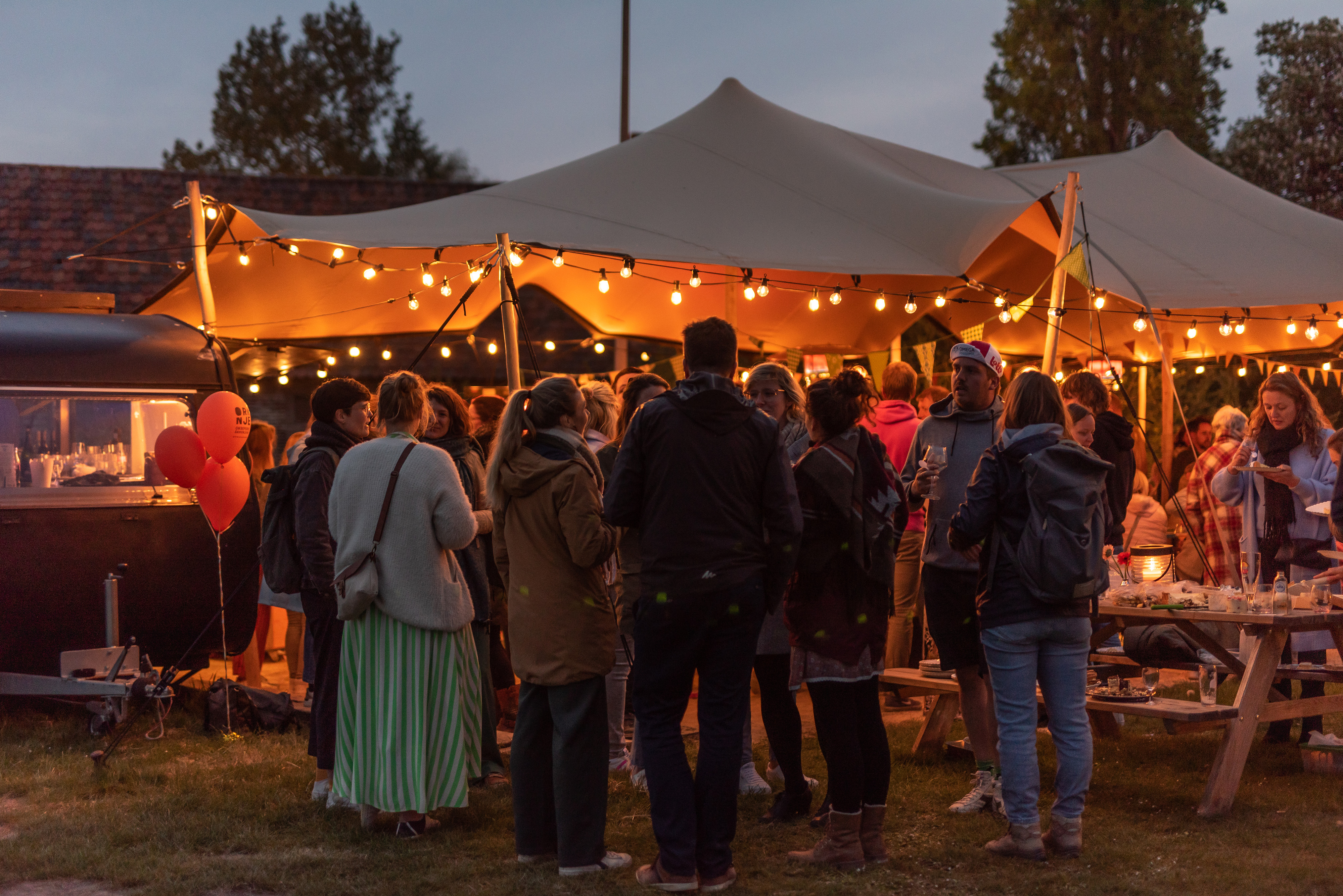 Groep medewerkers van Oranje aan feesttent