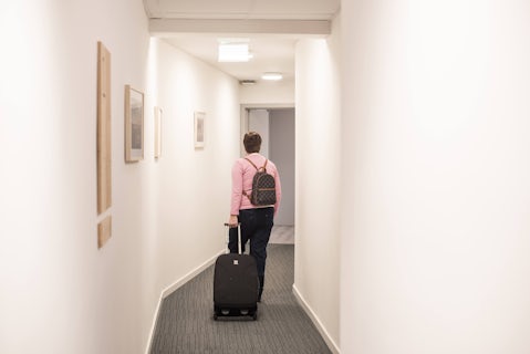 Vrouw wandelt met koffer door hotel O'mer