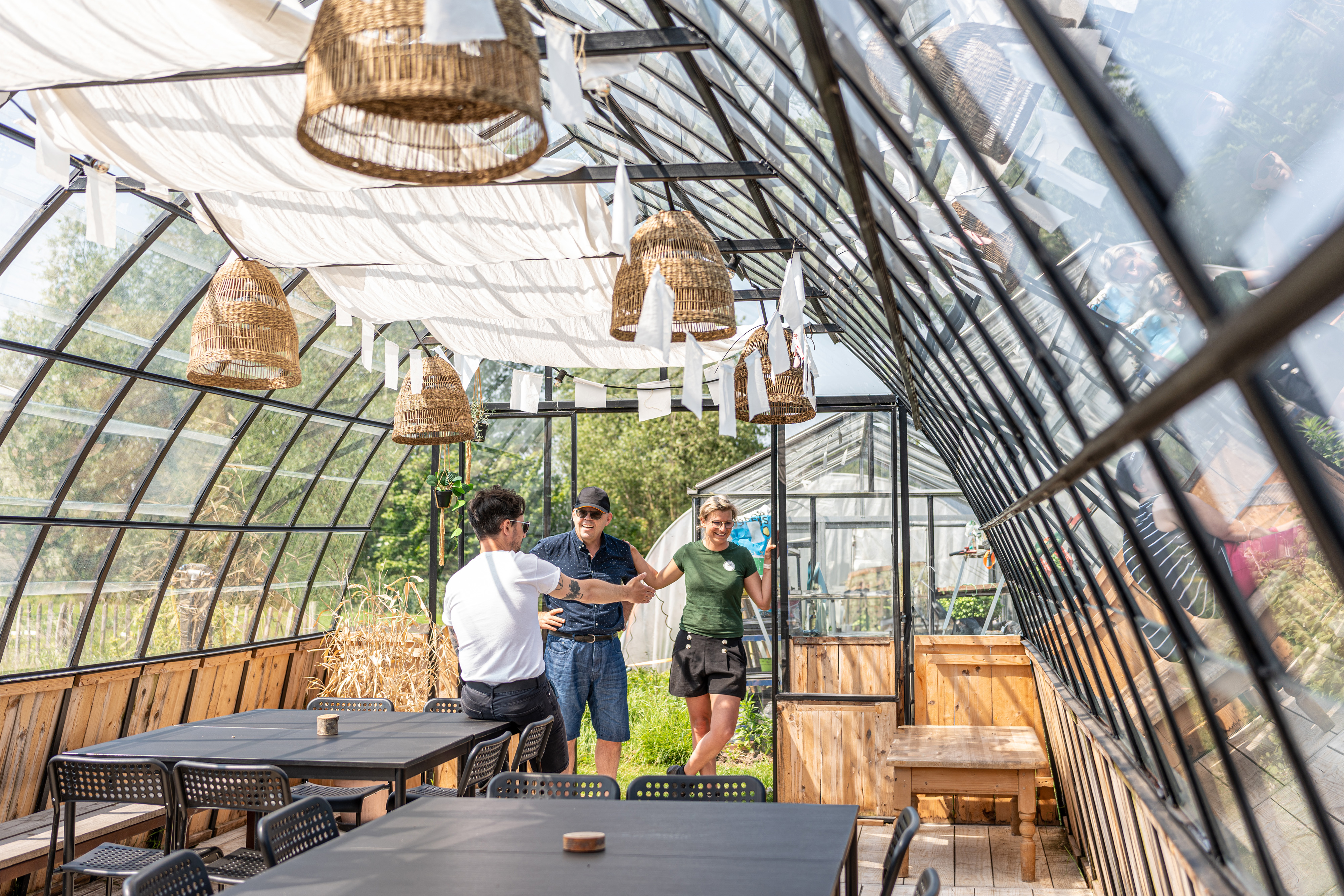 Vier mensen slaan een praatje in een sfeervolle veranda