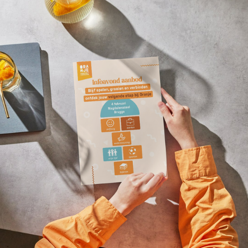 Twee handen houden de flyer over de infoavond vast.