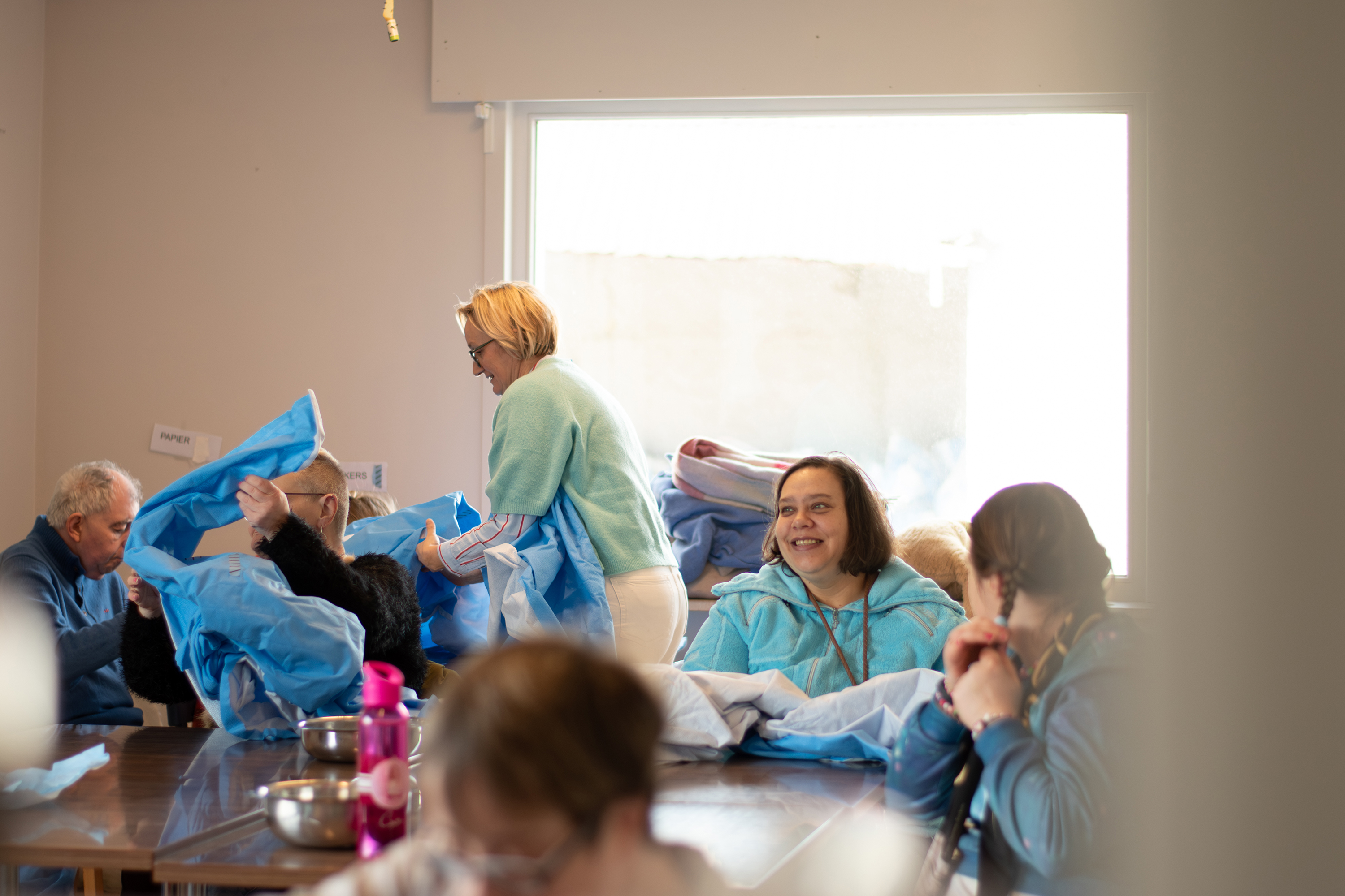 Groep deelnemers van dagbesteding ontstickeren sterilisatiedoeken om te recycleren
