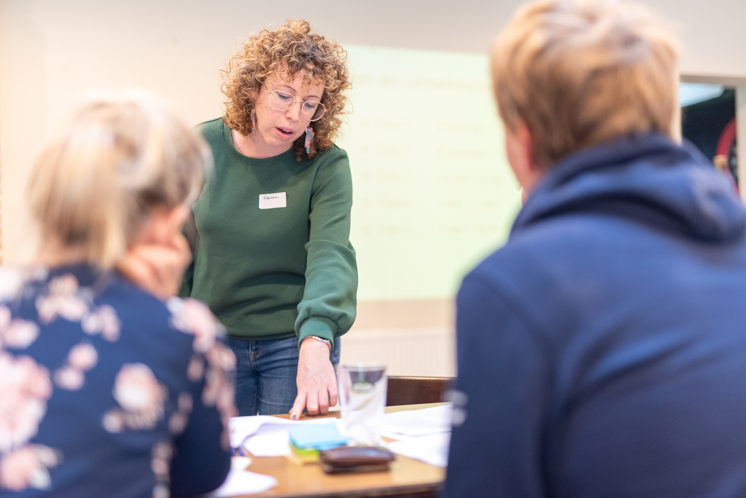 Medewerker inclusiemakelaar geeft uitleg aan twee deelnemers van een vorming