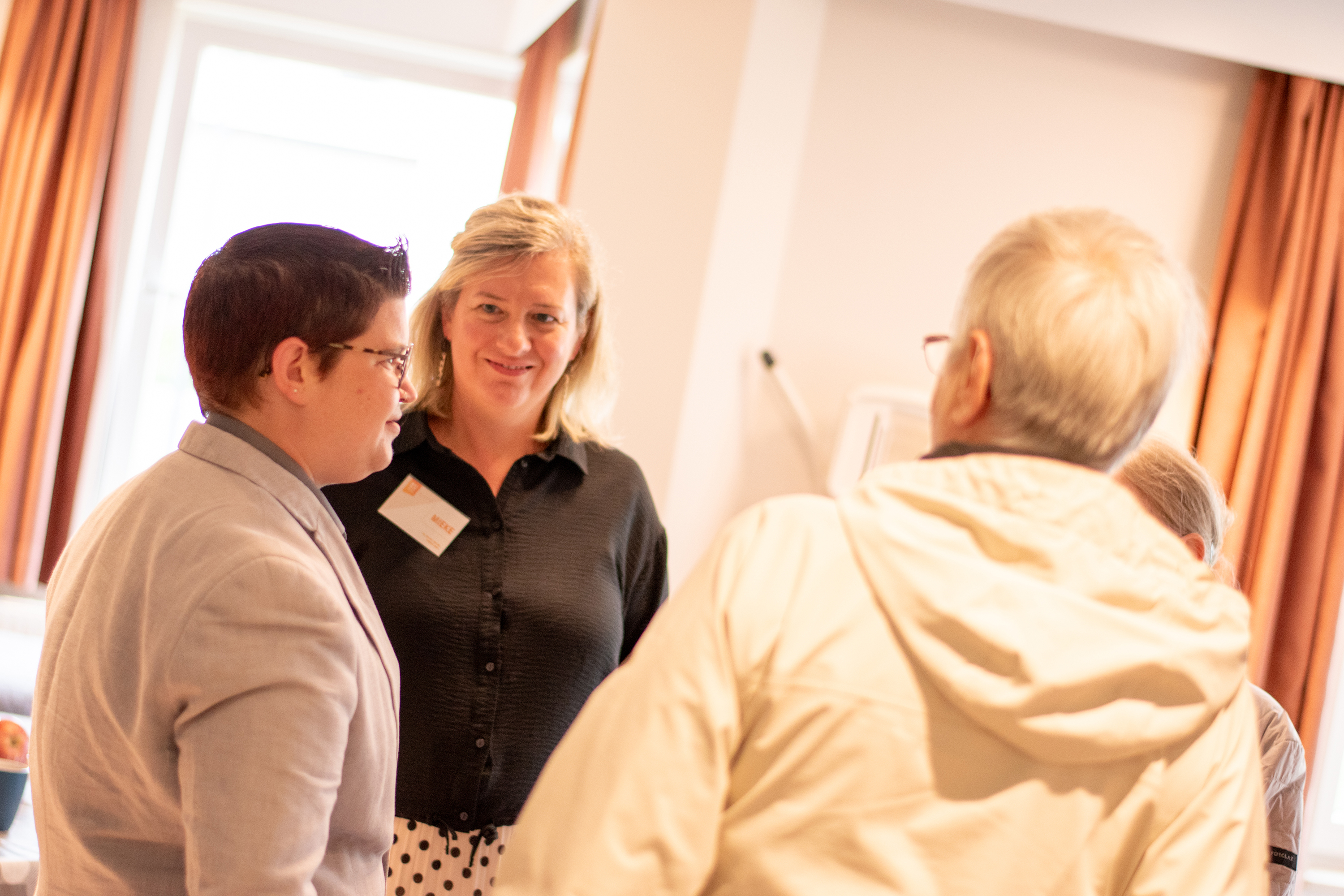 Drie mensen in gesprek in een woondienst