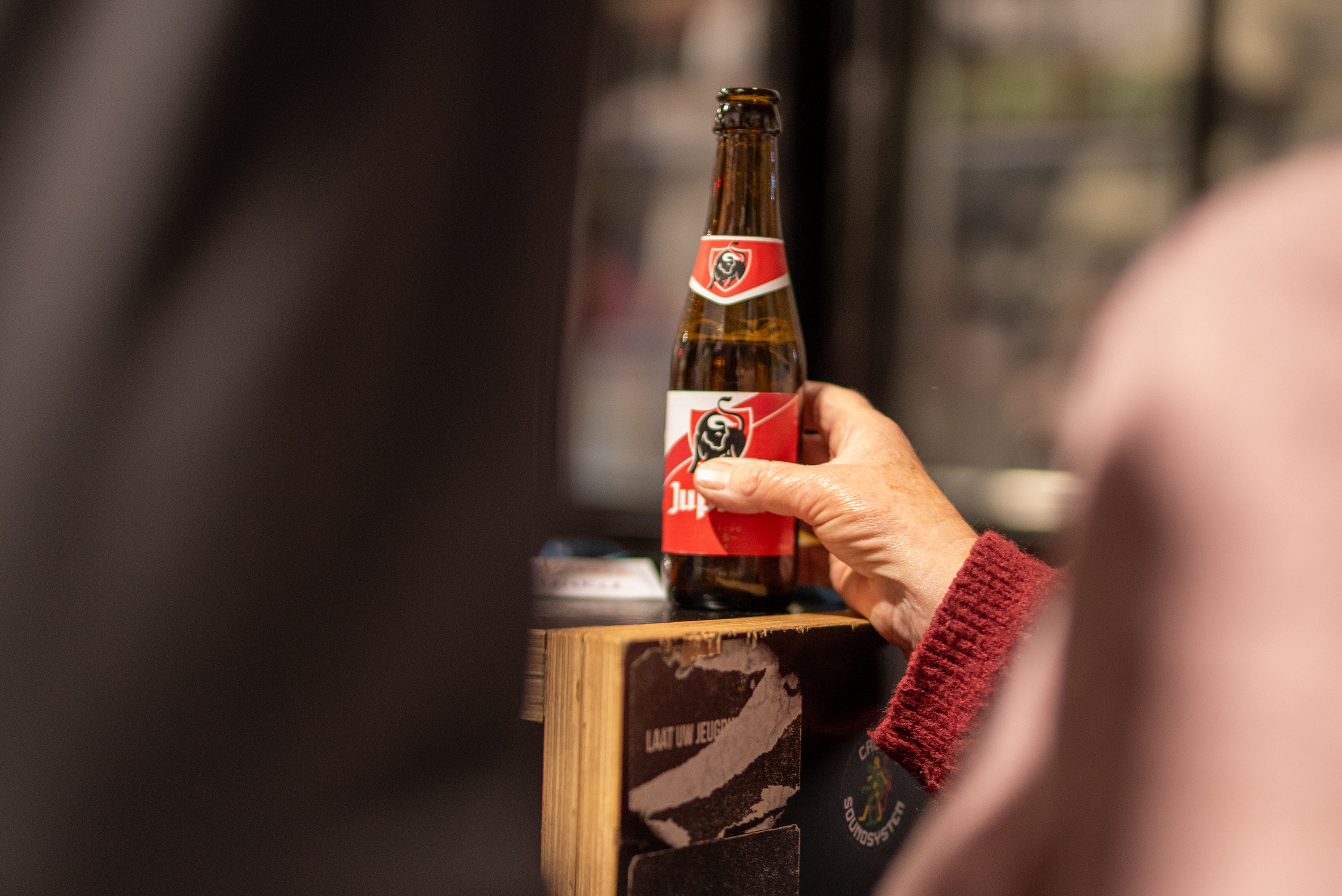 Een hand die een pintje vasthoudt.