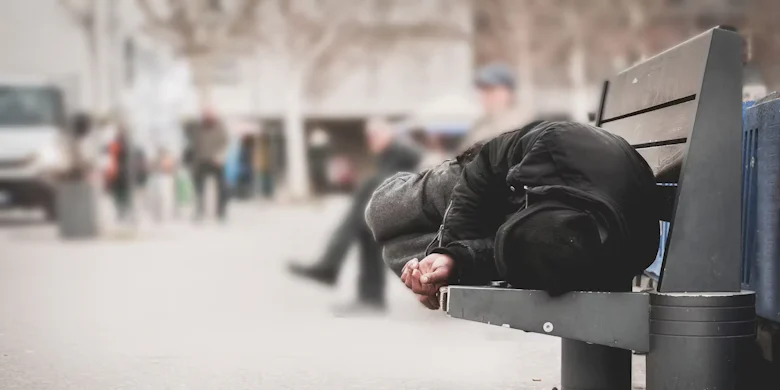 dakloze man slaapt op bank