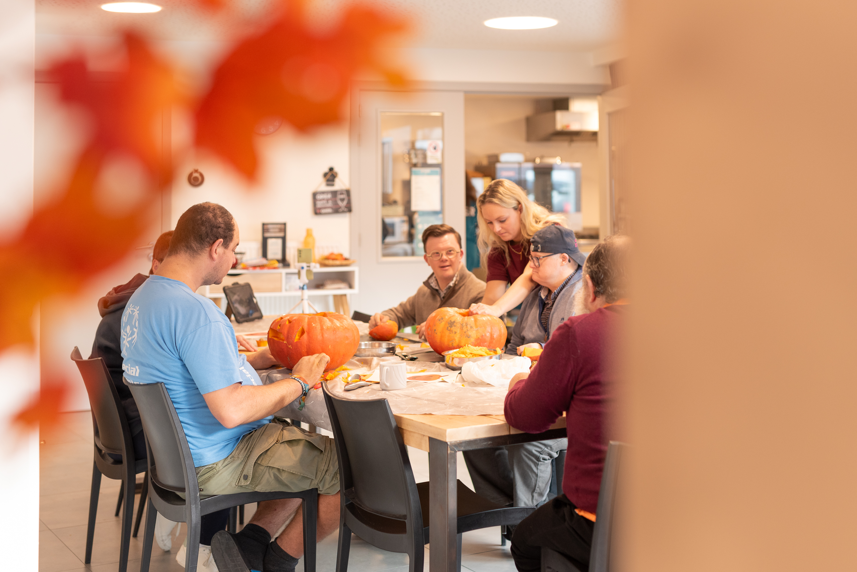 Groep hotelgasten snijden pompoen uit voor Halloween