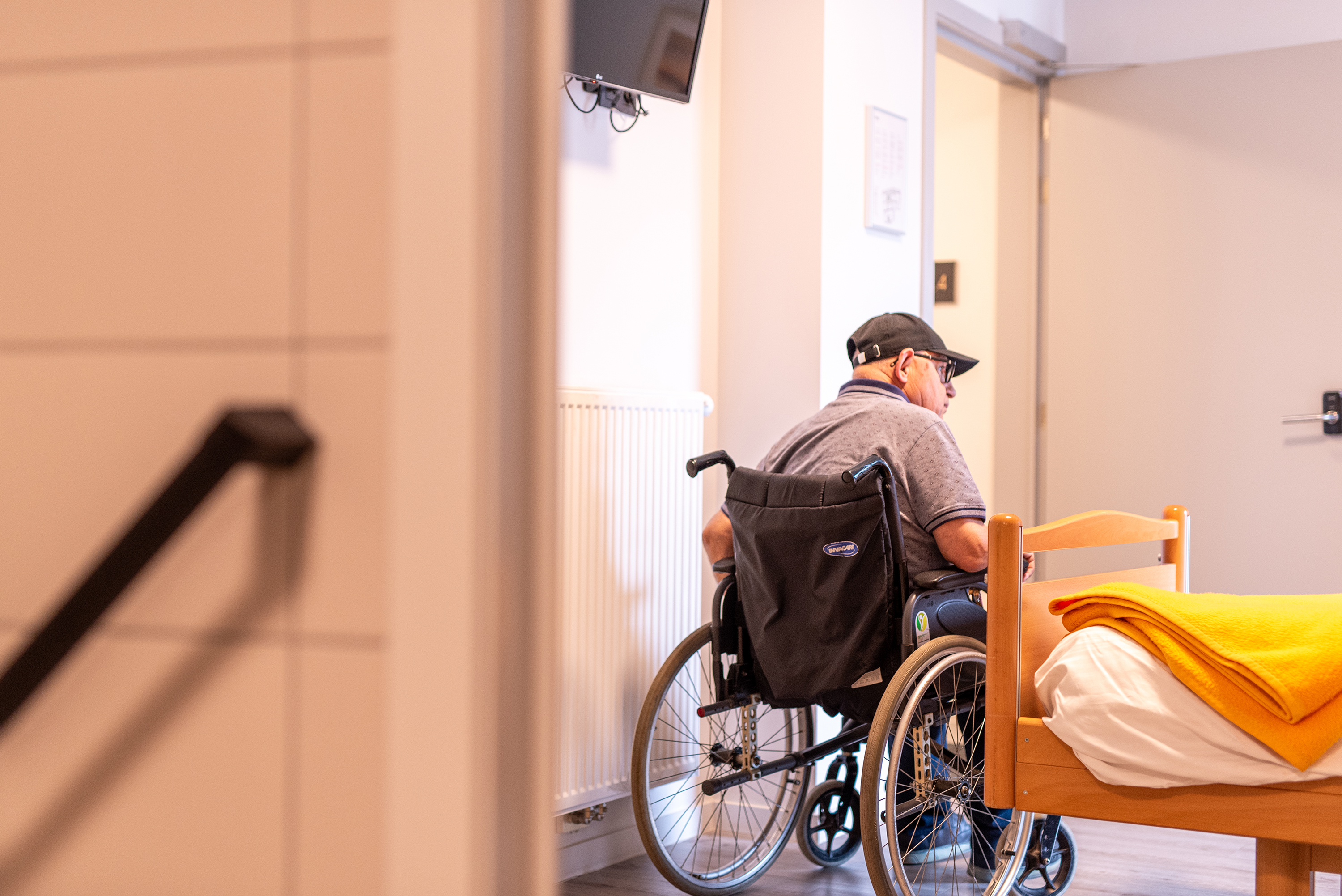 Man in rolstoel in eenpersoonskamer