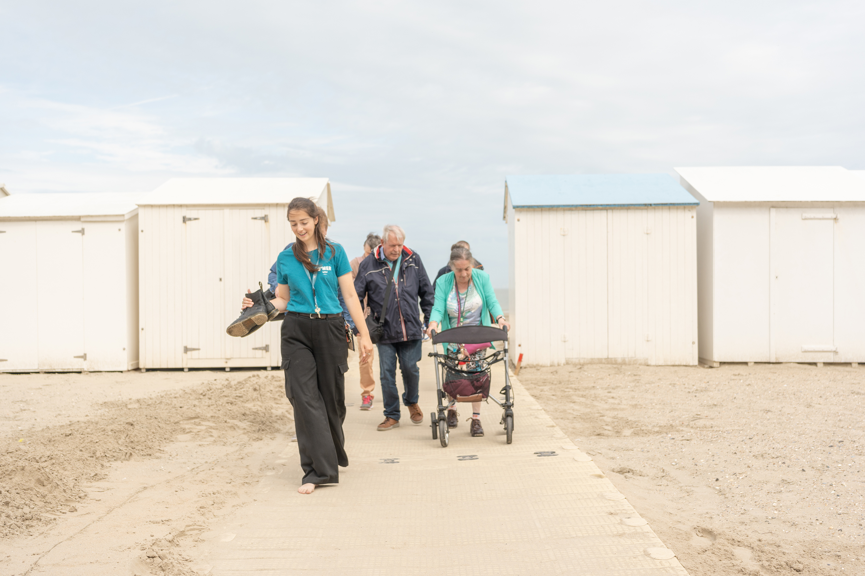 Groep hotelgasten wandelen over strand