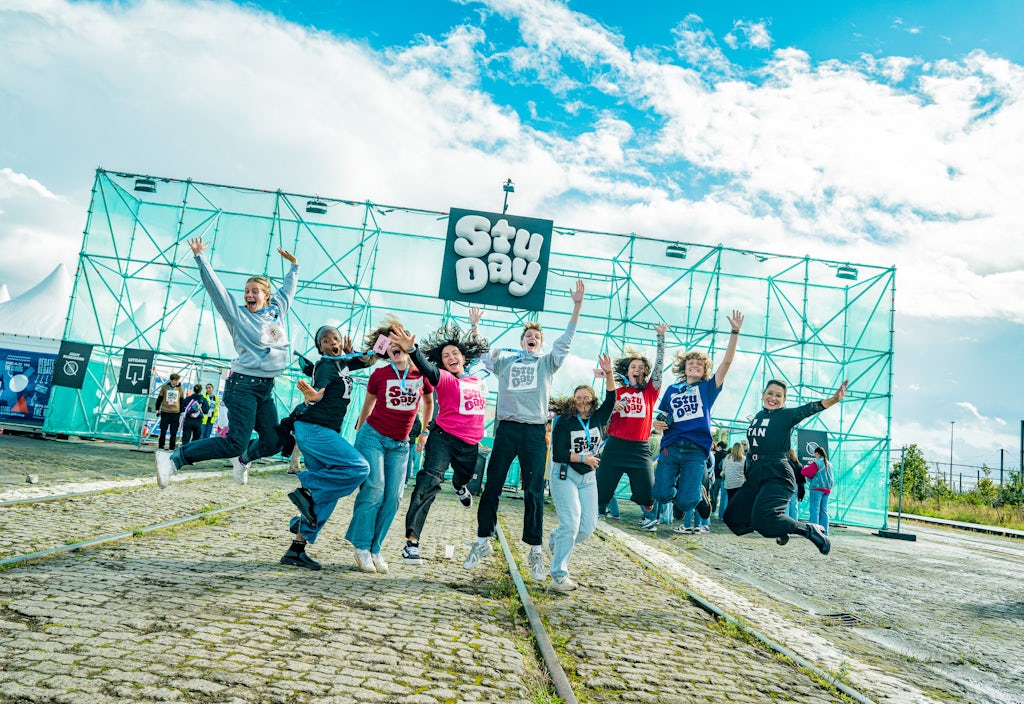 Studentenmedewerkers voor de ingang van StuDay