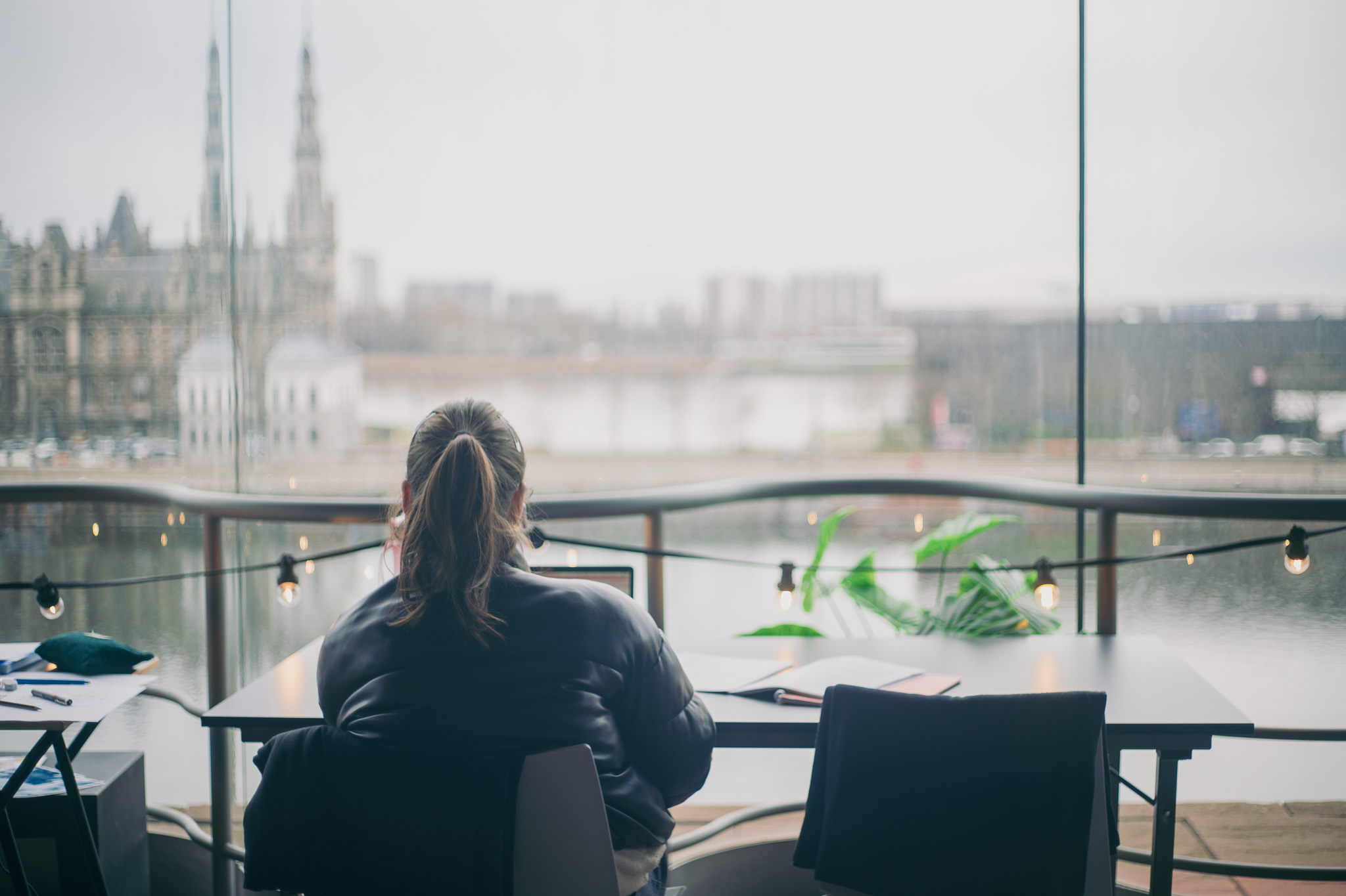 Zicht op een uitzicht van het MAS met op de voorgrond een blokkende student die naar buiten kijkt.