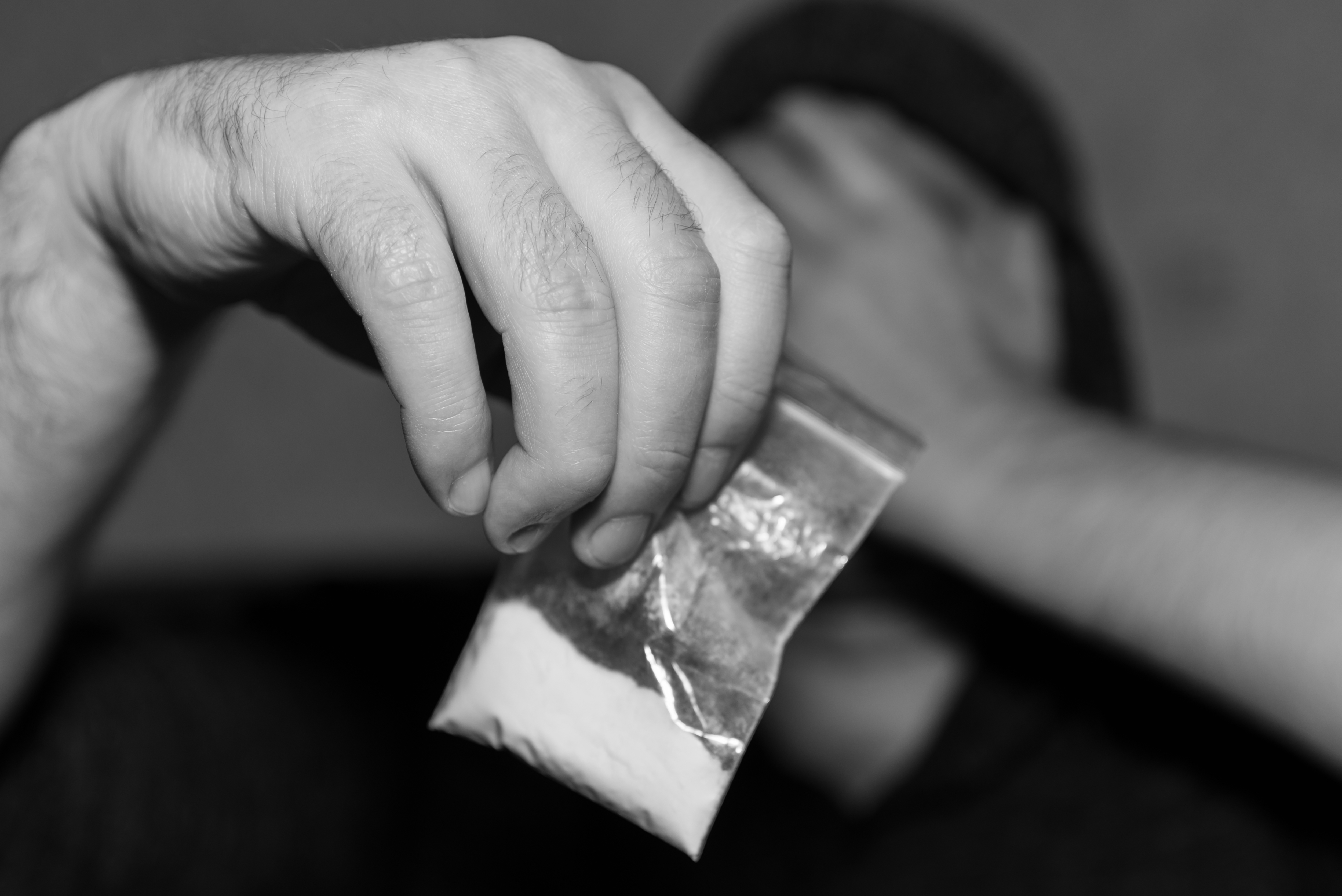 Man holding plastic bag with drug