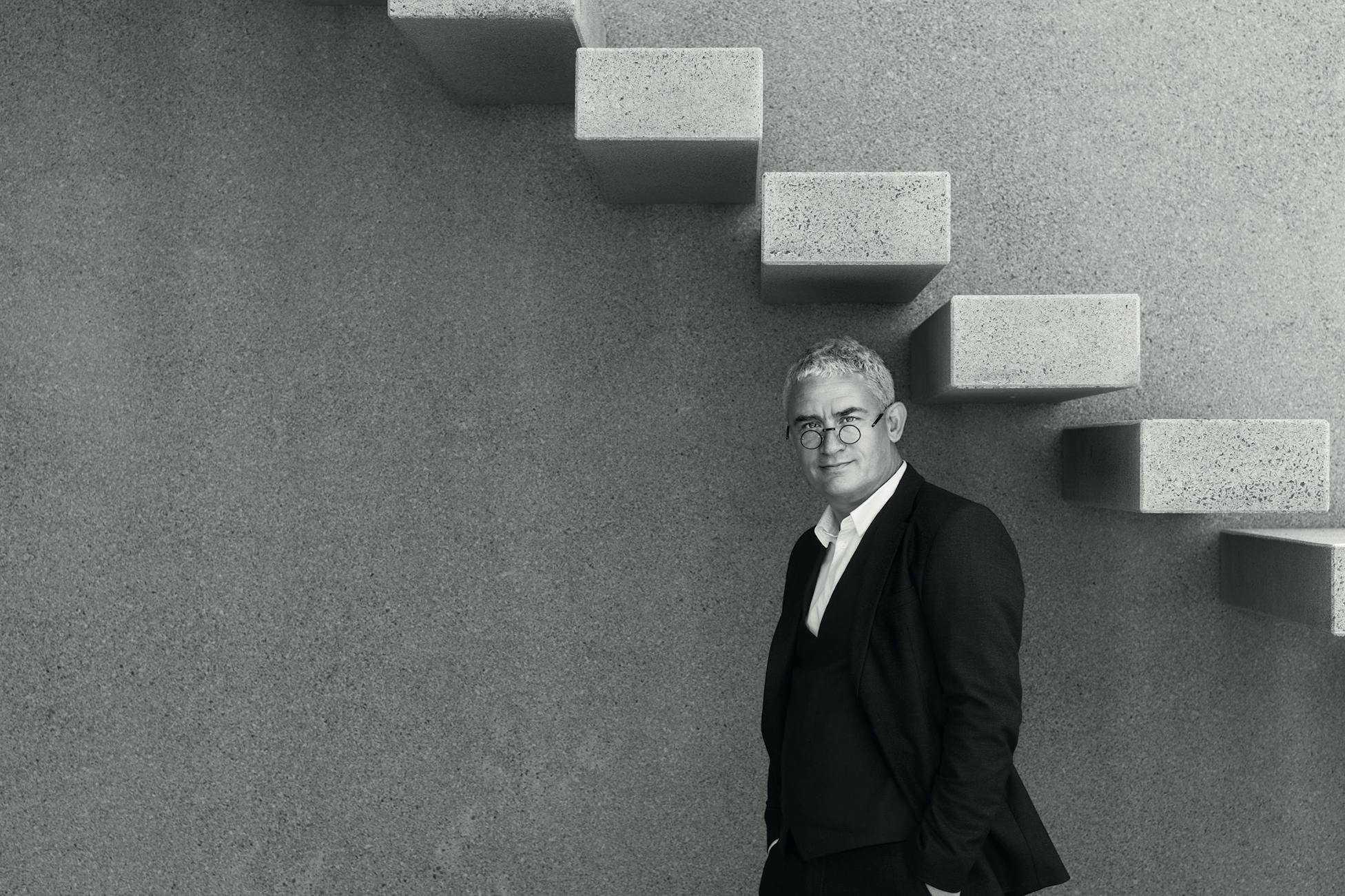 a man standing under a concrete staircase